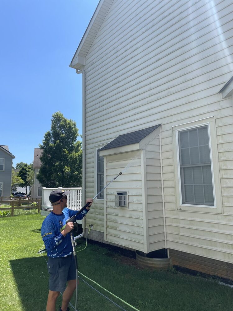 Studs With Suds crew member soft washing house siding in Laurel, Maryland